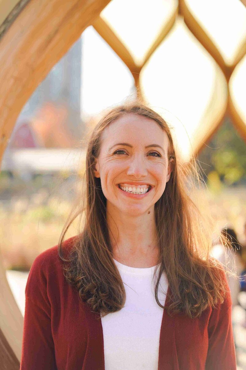 Megan Anderson smiles in front of a large, artistic structure.