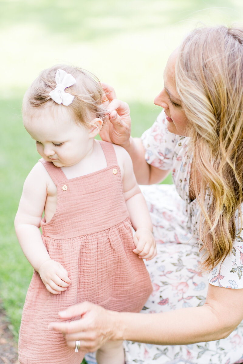 sweet mother fixing details during their motherhood portrait session