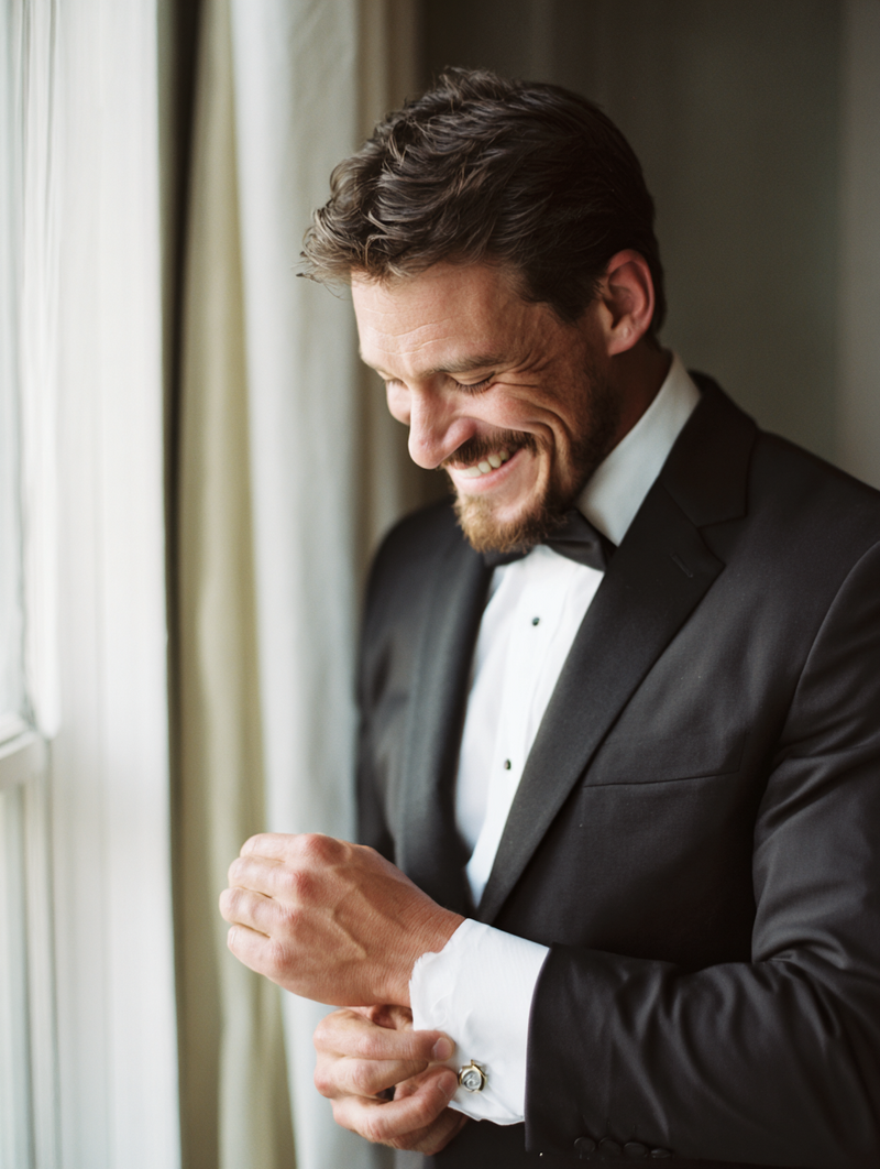 krista5123_Groom_adjusting_cufflinks_in_natural_light_near_wi_ed63e94b-df3a-4cd4-8dd0-8b9e4aa0a9b1_2