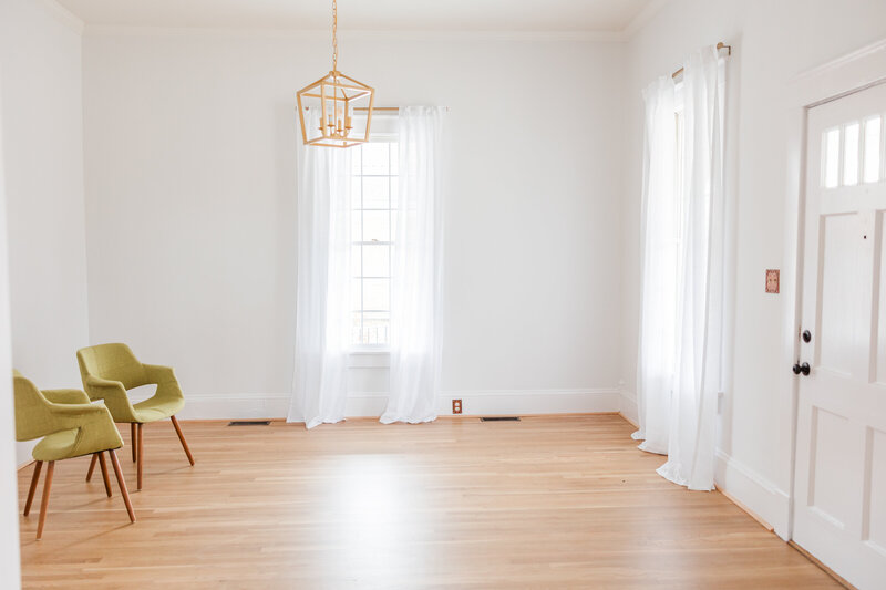 a bright room with white walls and wooden floors