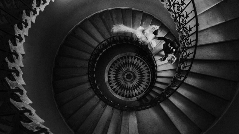 A black and white photo of a couple walking down the stairs.