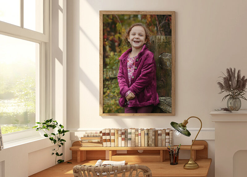 Portrait of a little girl wearing a purple jacket hanging on a wall over a desk