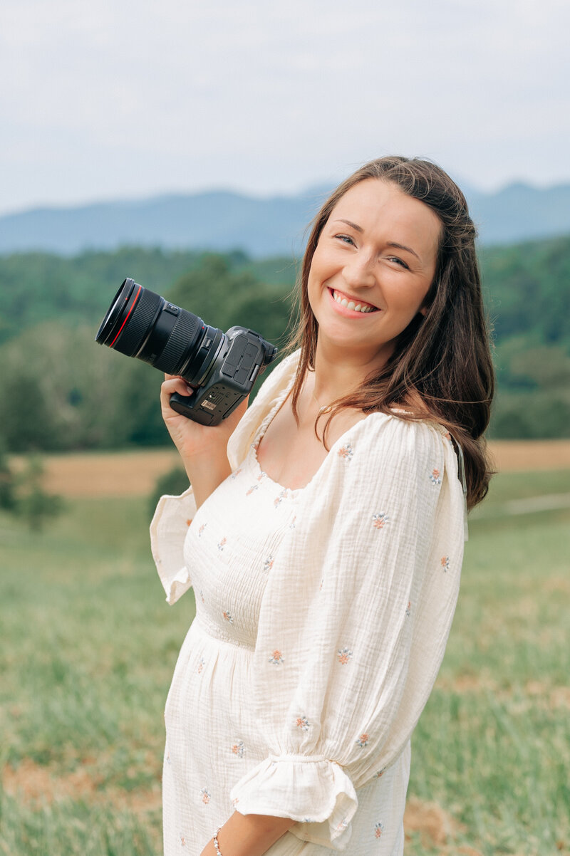Photographer poses with canon camera in the mountains of WNC at the Biltmore Estate in Asheville, NC