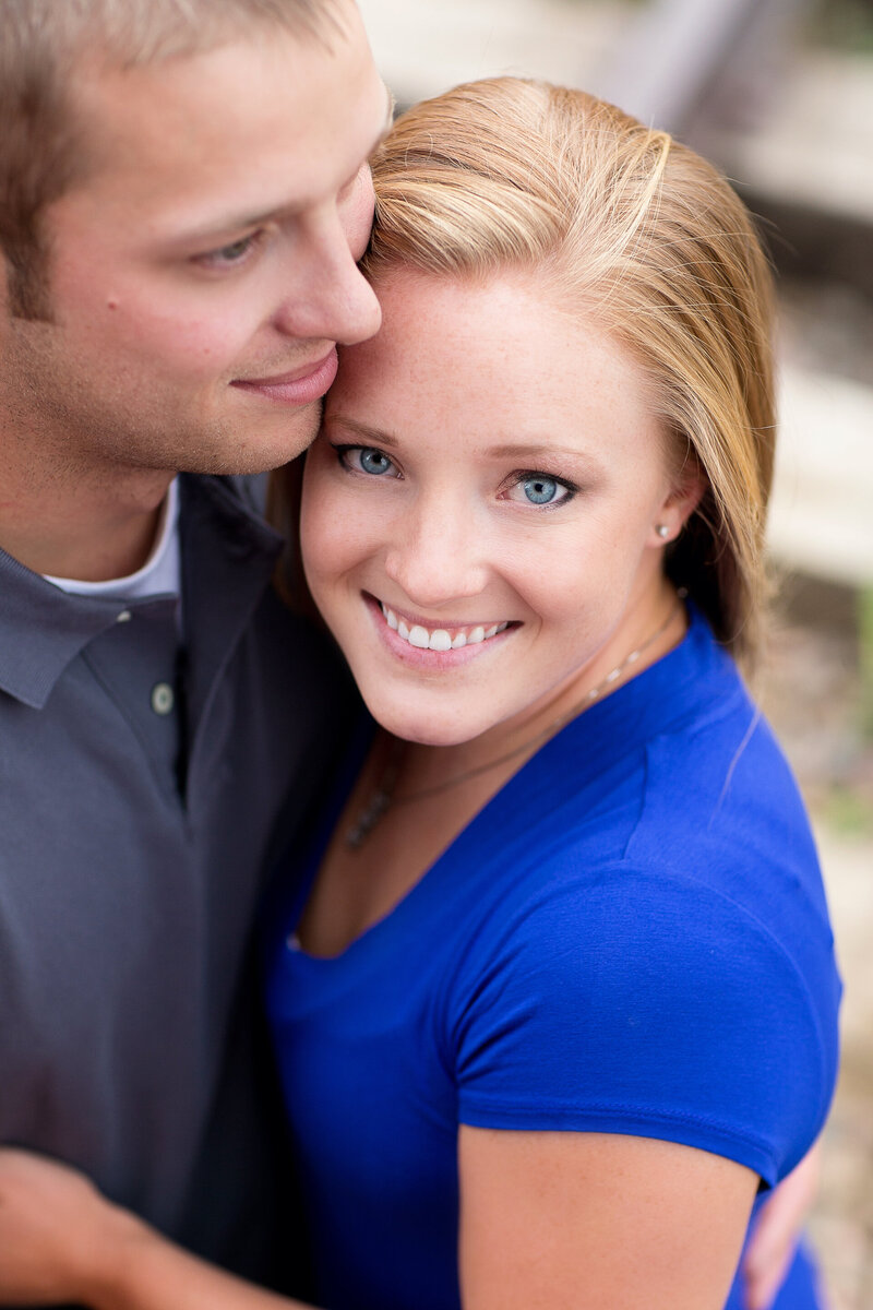 Engagement portrait of a woman and her fiancé.  She is wearing royal blue and he is in a navy collared shirt