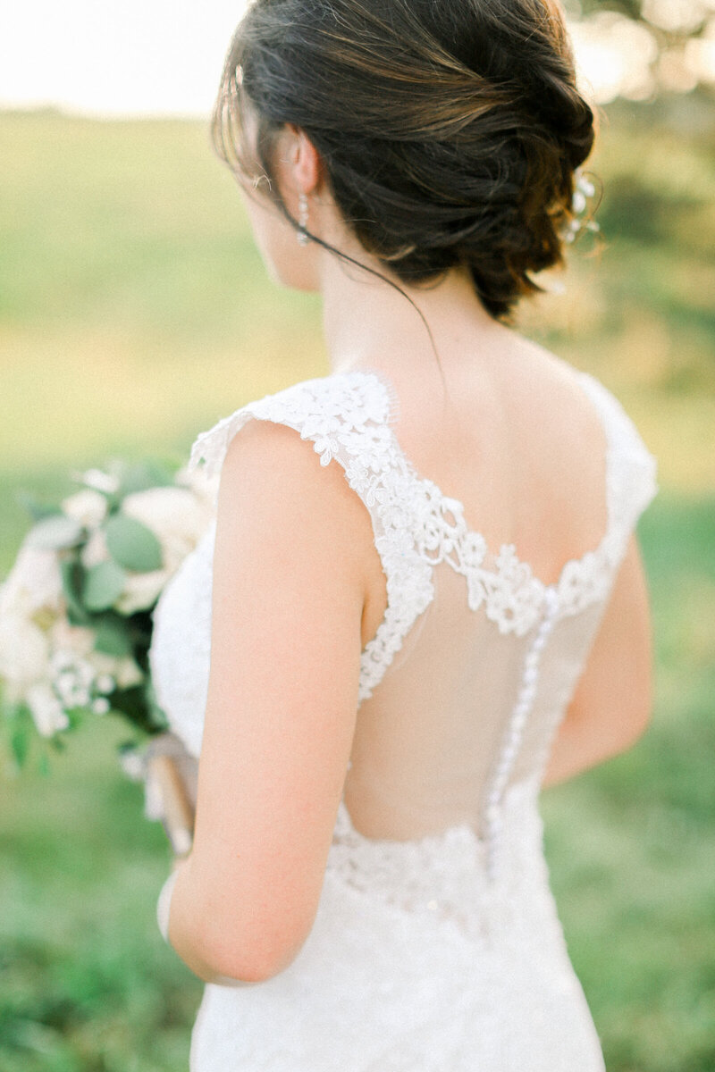 bride-with-romantic-braided-hair-style-bride-wearing-elegant-cap-sleeve-lace-wedding-dress-with-mesh-back-wedding-at-big-cedar-lodge-shooting-academy-in-branson-mo-by-branson-wedding-photographer-kathryn-faye-photography