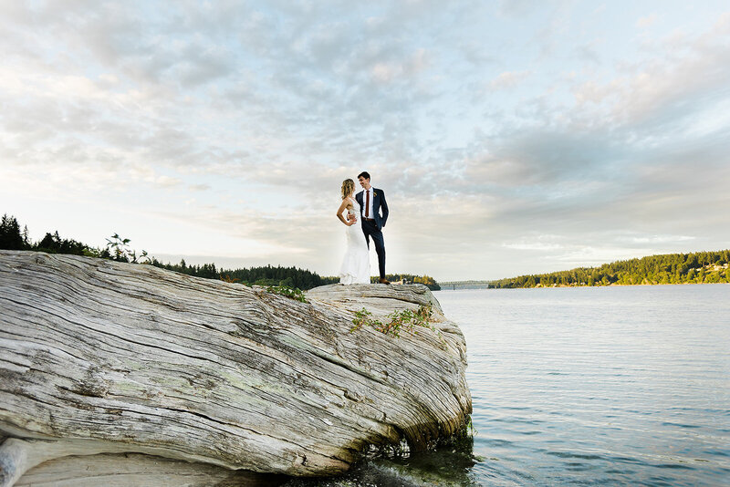 Bride and groom standing on a rock far away and looking at each other