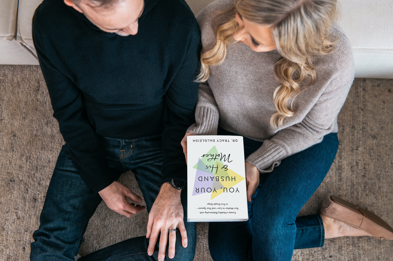 Man and woman holding book together on couch