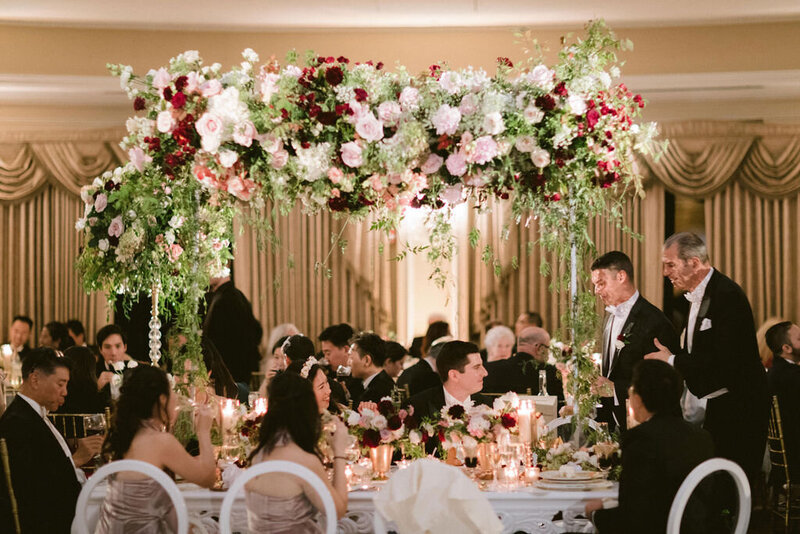 elevated floral centerpiece on head table at wedding