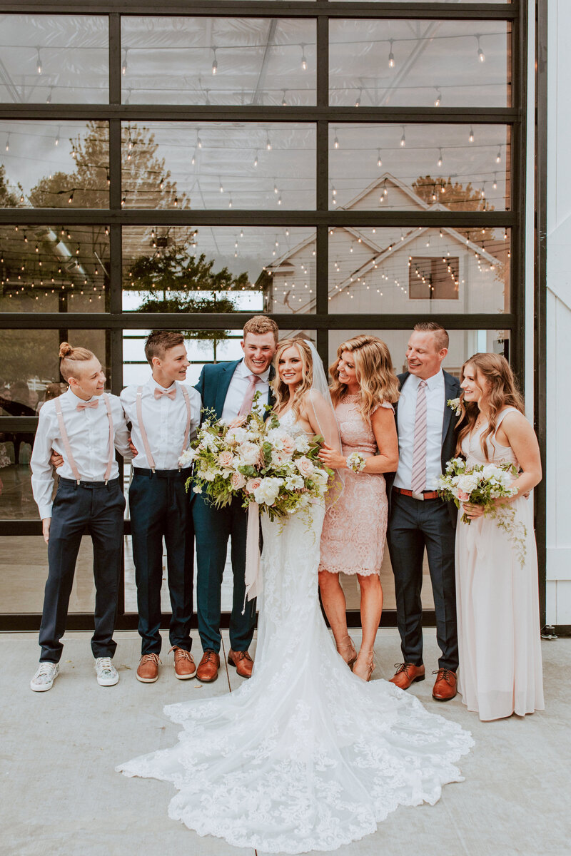 A bride and her family pose in front White Barn.