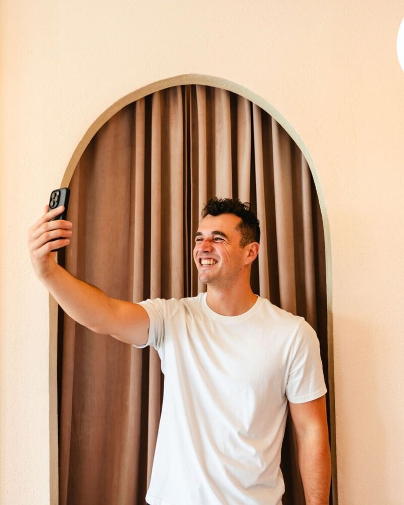 male influencer assistant taking a selfie on his cellphone