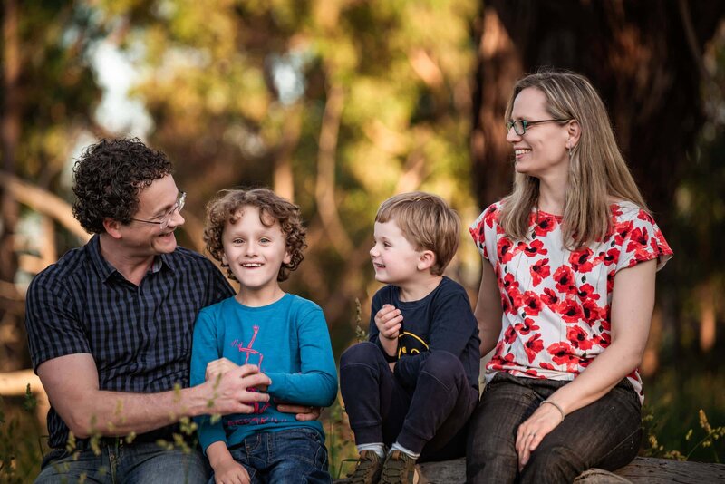 family of four sitting on a log in Upwey