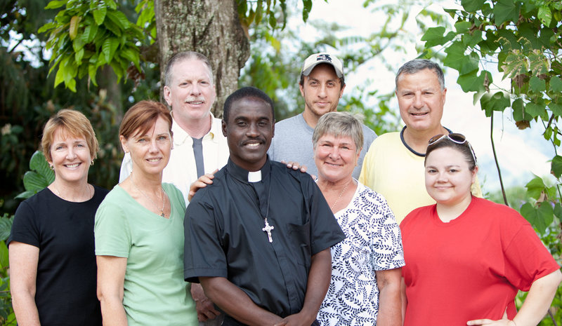A group of 7 people with a catholic priest in Duval Haiti on a Mission Trip with the Parish Twining Program from Indiana