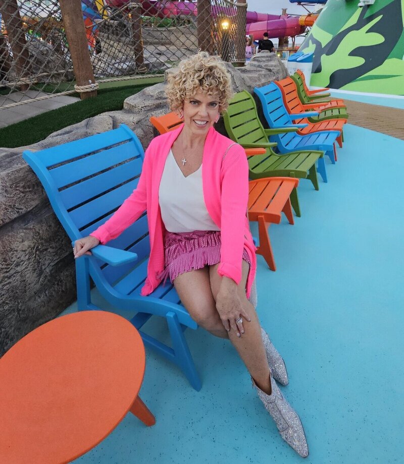 personal vacation planner for carnival cruises, GG Mack, sitting on a chair