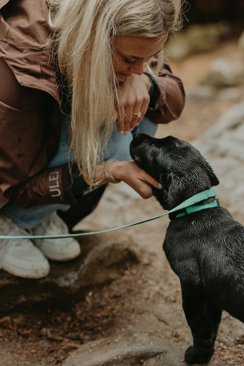 woman shows her puppy her engagement ring