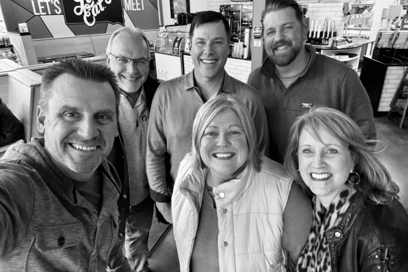 Lon Stroschein with fellow Normal 40 Inner Circle members smiling at an in-person meetup, embodying connection and clarity