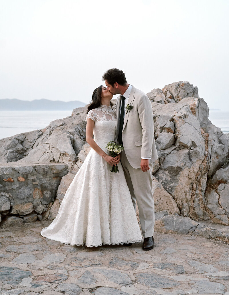 bride and groom kissing by the sea