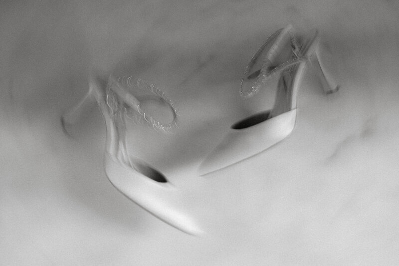 Black and white photo of a pair of white heels