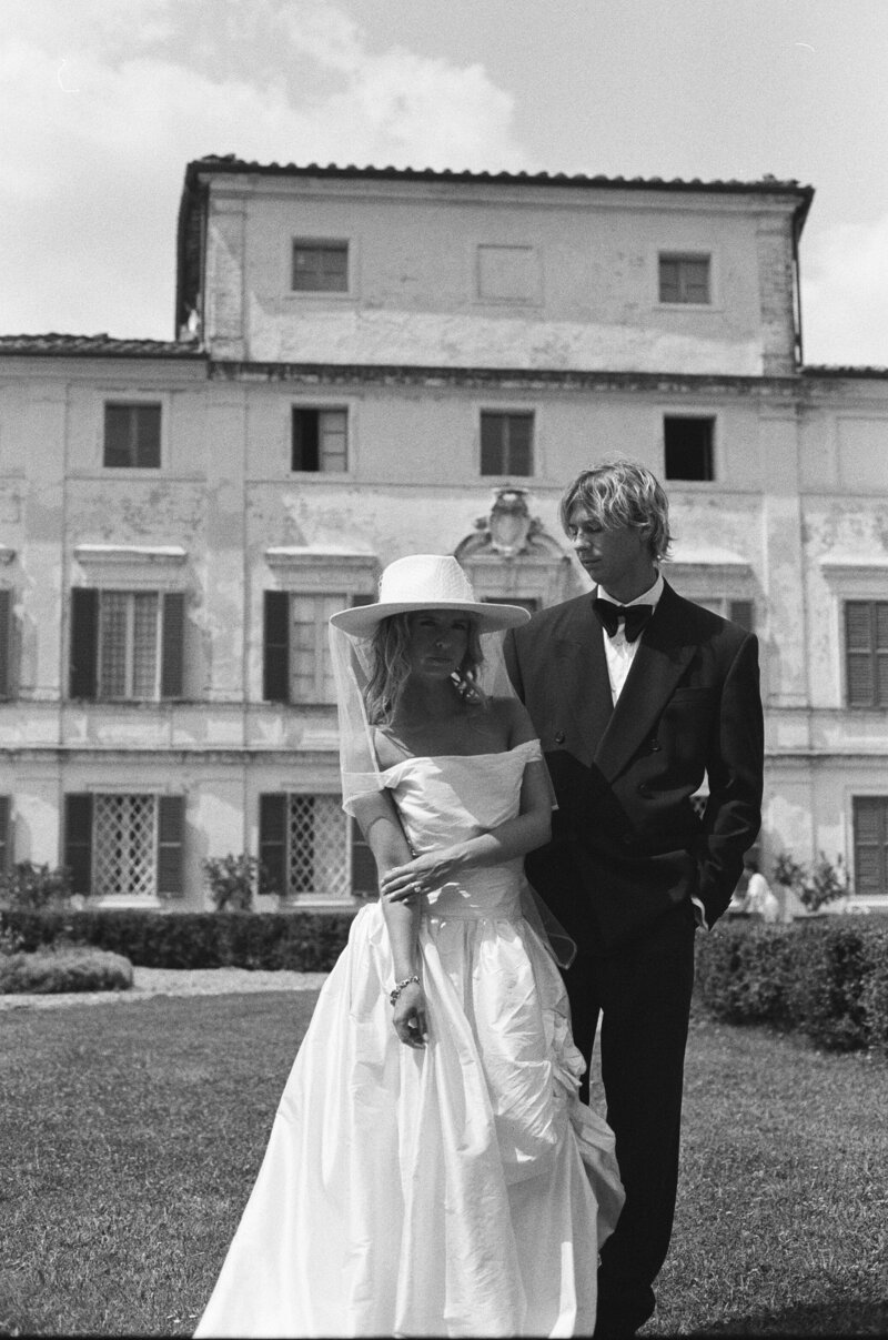 A person with their arms around their partner's shoulders on their wedding day 