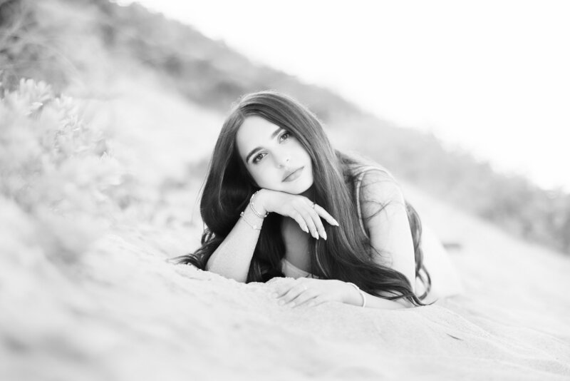 Senior girl laying on the beach for Orlando Graduation Photography session
