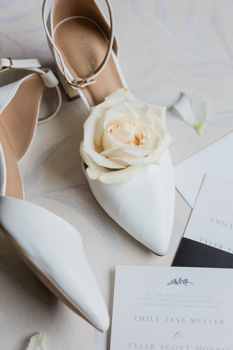 A creative flat lay image of a wedding detail photo of a shoe and rose in West Palm Beach.