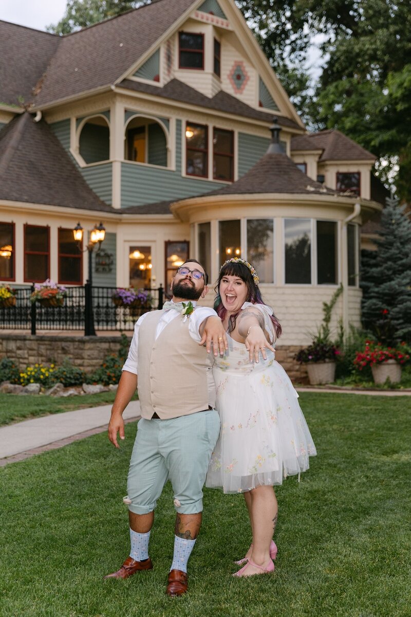 Bride and groom laughing together in front of The Tapestry House in Laporte, Colorado — garden-party wedding 