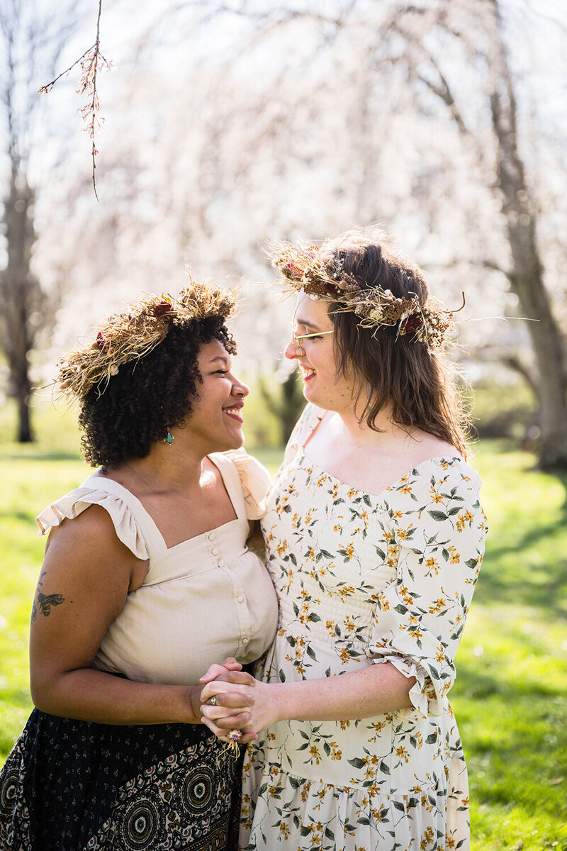 A lesbian wedding couple pose together in the backyard of  Vrbo they rented for their elopement in Roanoke, Virginia.