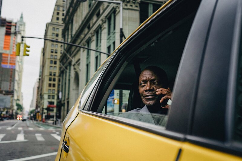 Man taking a phone call while looking outside of a taxi
