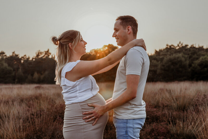De hand van een volwassene omvat zachtjes de hand van een pasgeboren baby