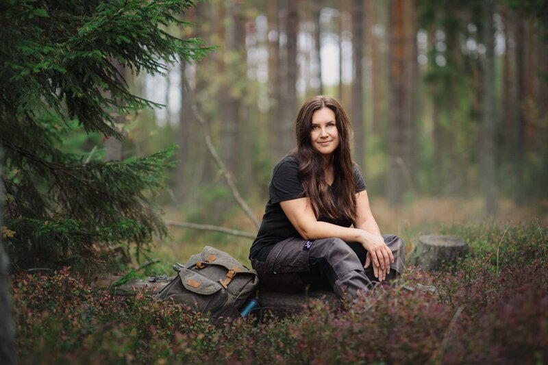 Brandingbild på fotograf tagen utomhus i skogen, sittande på en stock