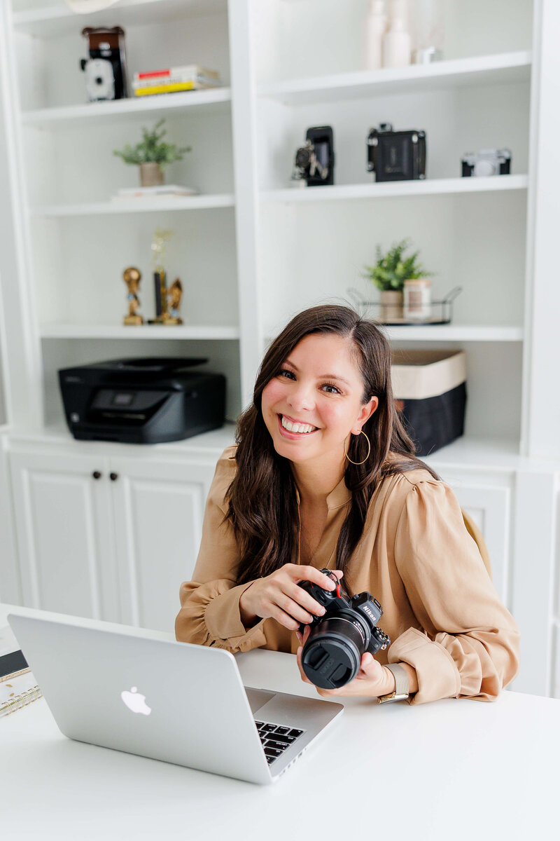 Lifestyle headshot of photographer holding camera in white office