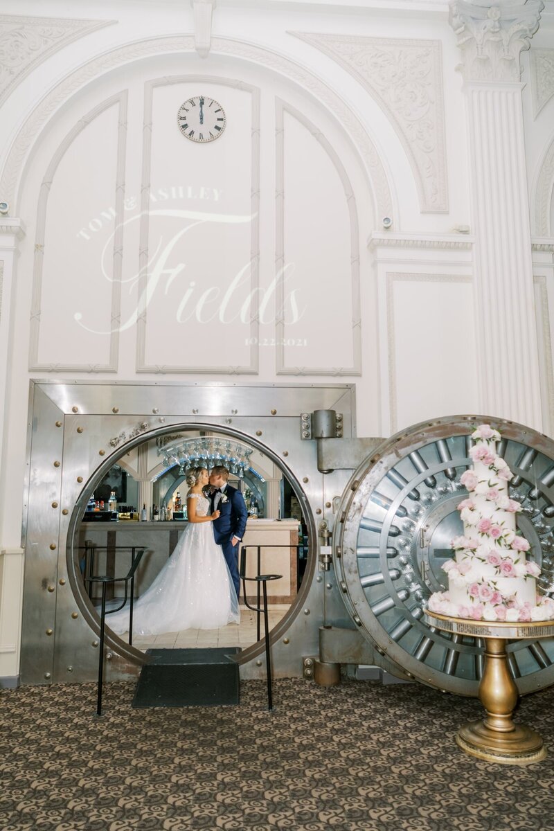 A circular mirror on the left shows a bride and groom kissing, a wedding cake is on the right