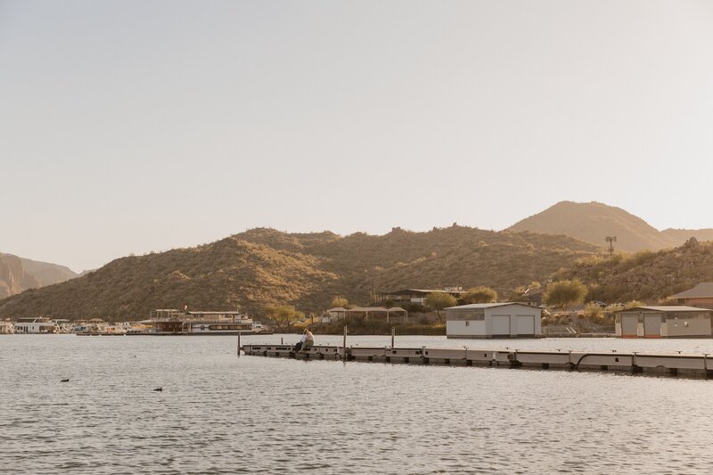 couple sits on dock for couples photos in arizona