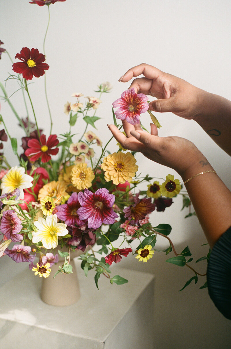 June Bloom Owner, Joanne, arranging floral display.