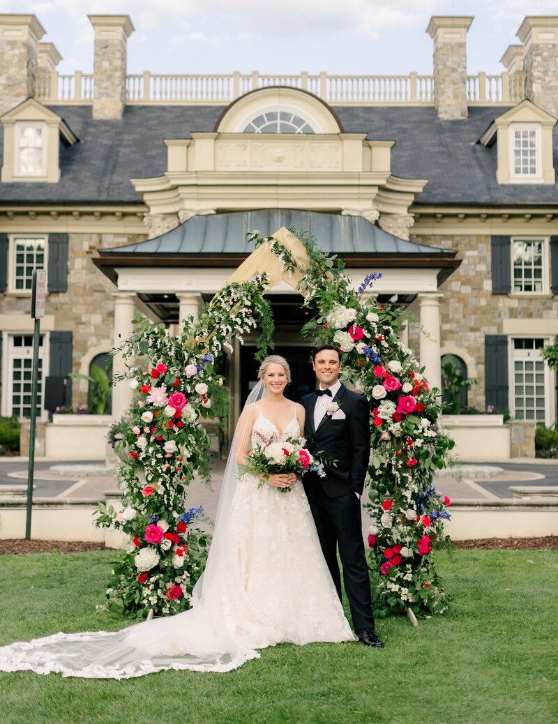Red, white, and blue flowers covering a ceremony floral arch. Garden inspired wedding ceremony arch. Unique floral design for Eastern Shore wedding venues.