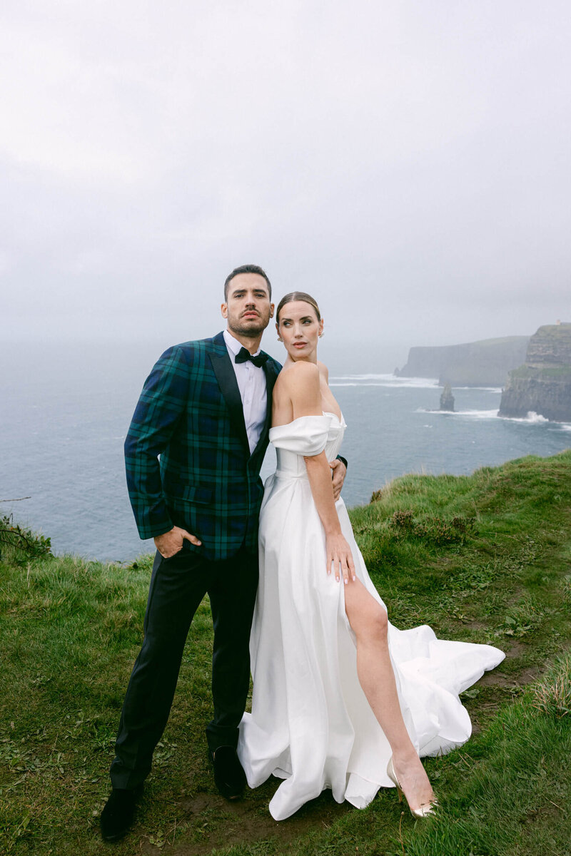 Couple posing for photos during their elopement at the top of the cliffs of Moher in Ireland