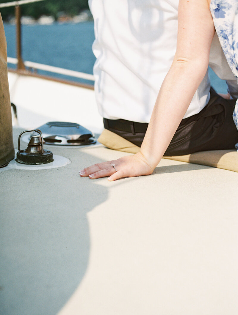 Close-up of bride’s hand showing engagement ring aboard a sailboat on Lake Michigan during an engagement session with Ohio wedding photographer