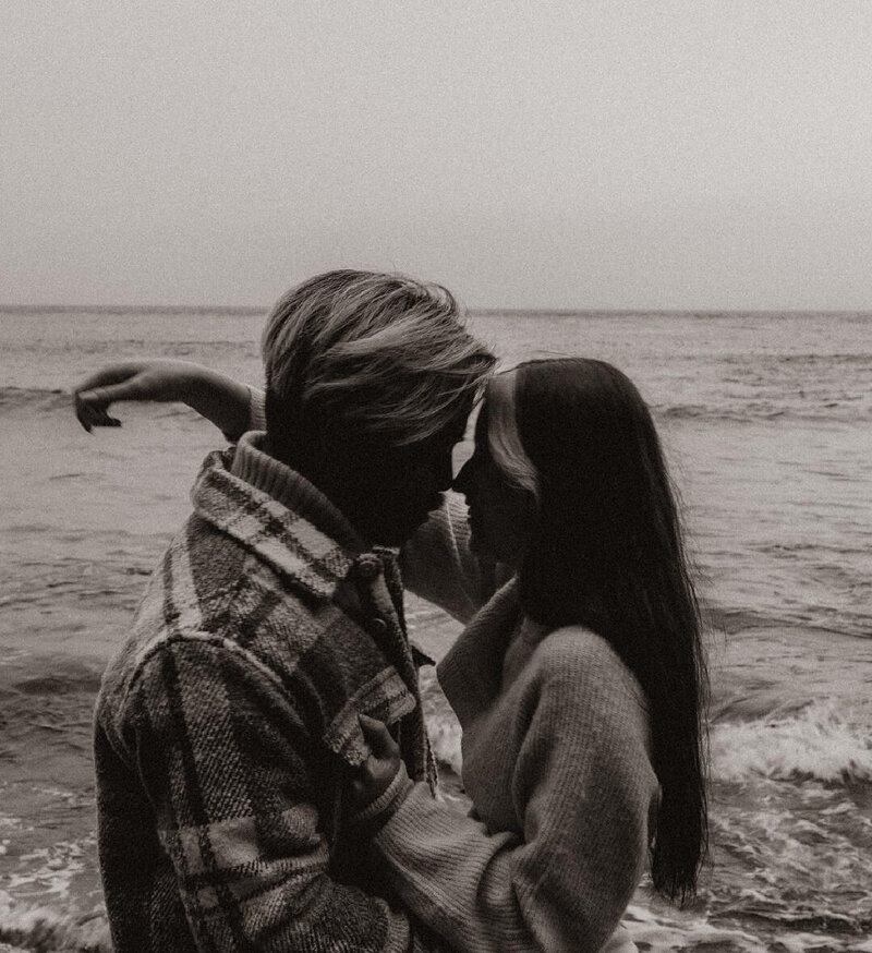 couple kissing with waves in the background