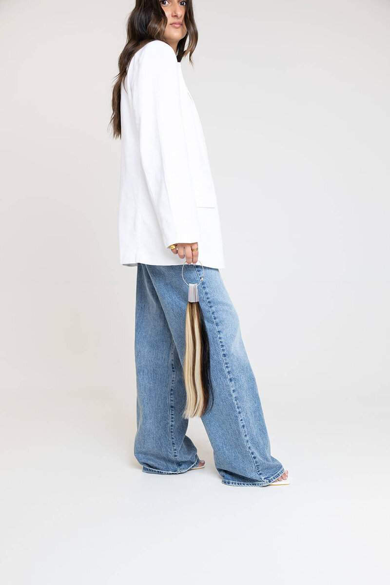 long-island-hair-stylist-in-white-jacket-and-blue-jeans-holding-hair-extensions-BFC-10