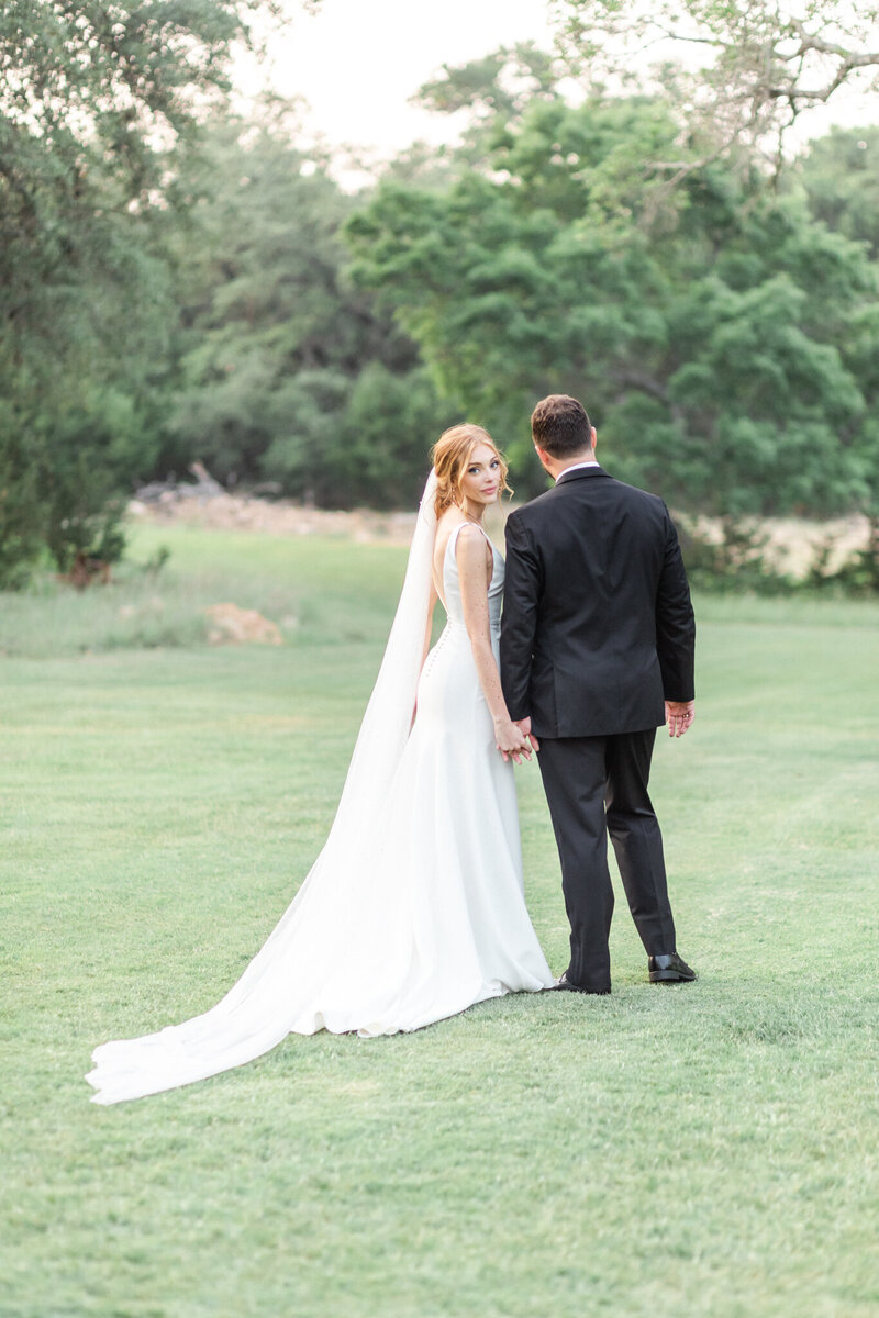 bride and groom walking while bride looks back
