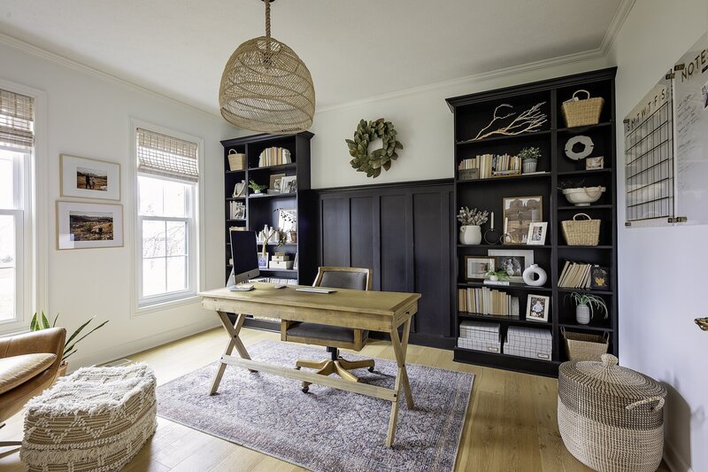 Modern office with dark walls, light wood floors and a large wood light fixture