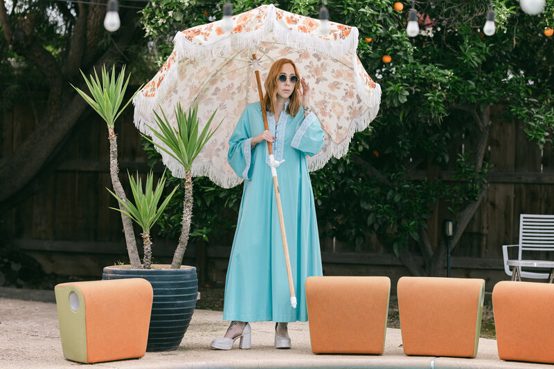 Fashion-forward branding photo of a woman in a vintage blue kaftan under a floral parasol, taken outdoors in Greenville SC by Dani Lacey Photographs.