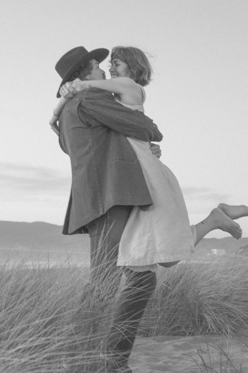 playful engagement photos in oceanside california with couple running and playing in the sand