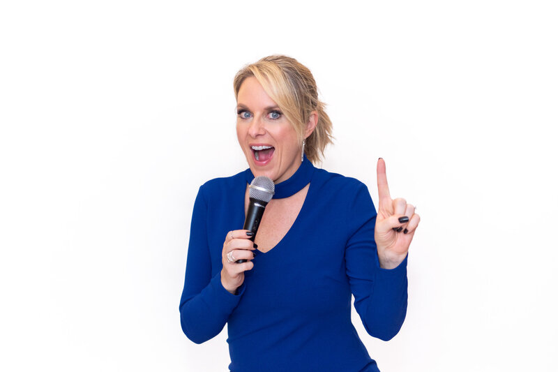 A woman holding a microphone and talking.