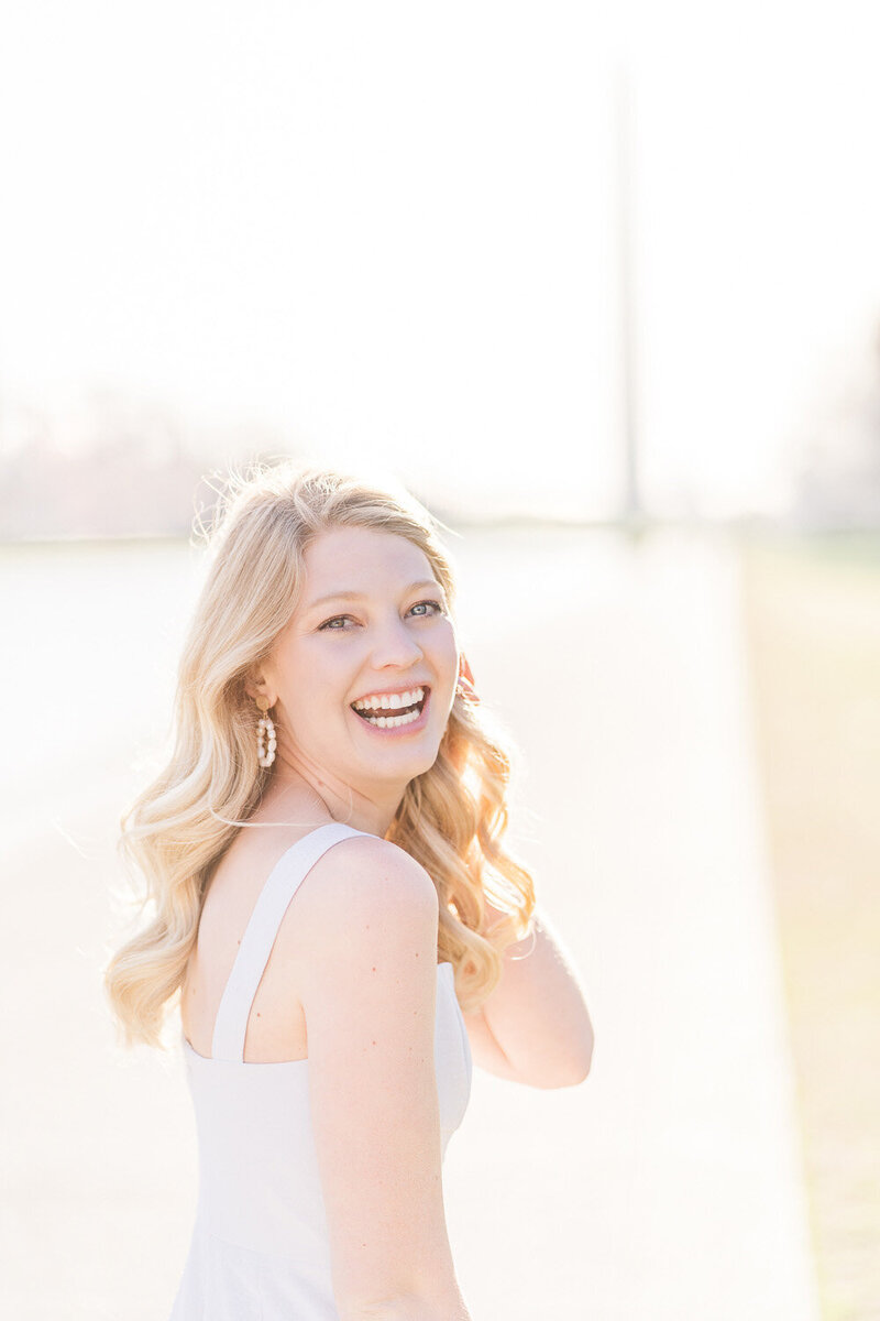 girl laughing looking back during senior session by the Reflecting Pool