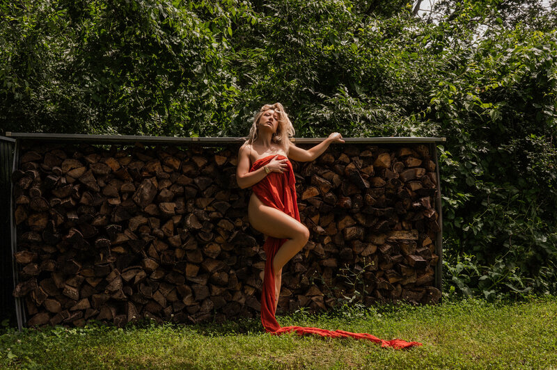 woman outdoor with fabric wrapped around her body near a pile of wood