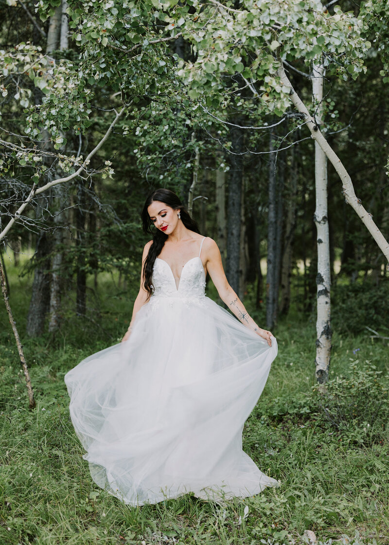A bride in the forest near the Pomeroy Kananaskis Mountain Lodge near Canmore, Alberta