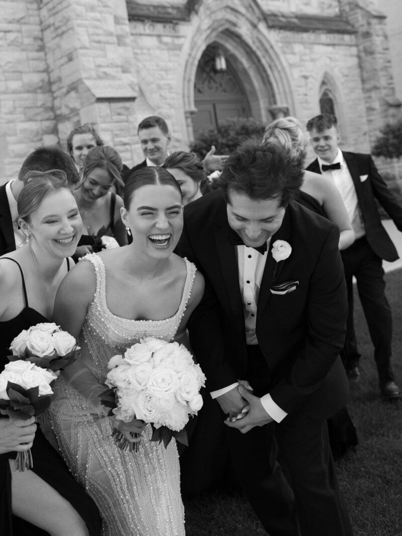 Bride and Groom laughing with wedding party at their Wisconsin wedding.