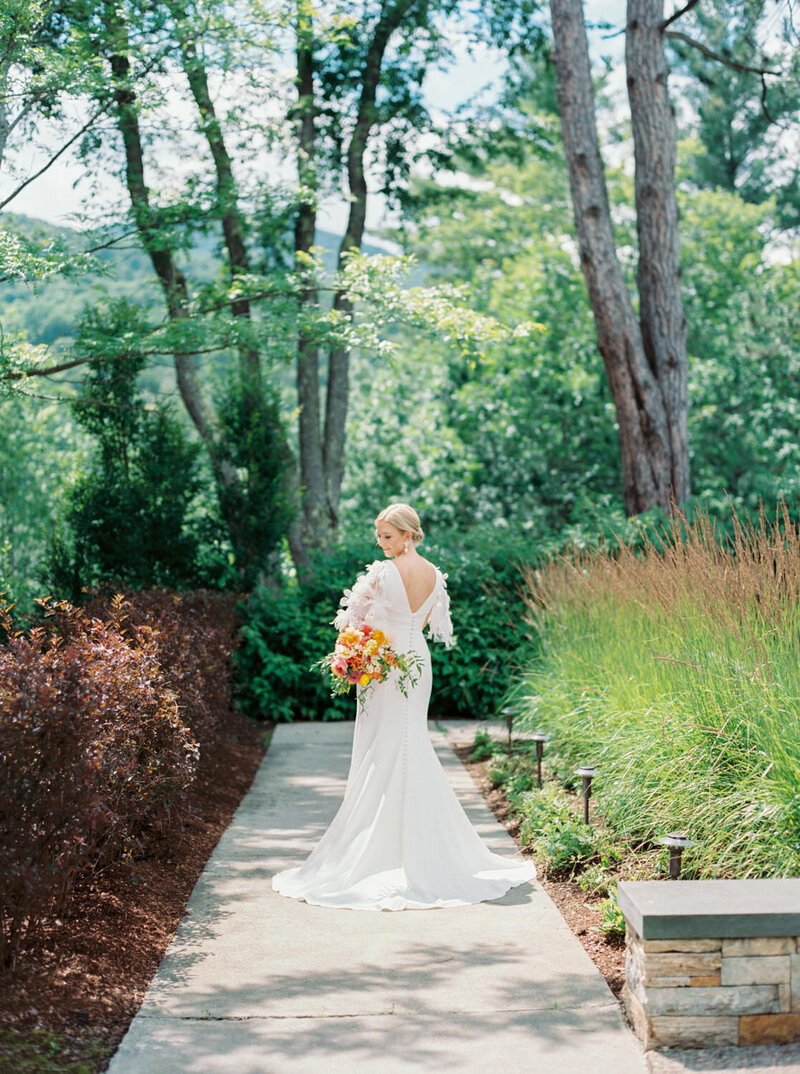 Elegant bride looks over her shoulder at her Vermont Wedding.