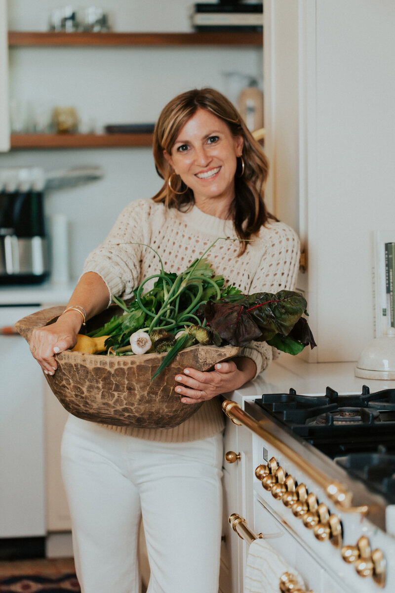 Sam in kitchen holding a big bowl of veggies