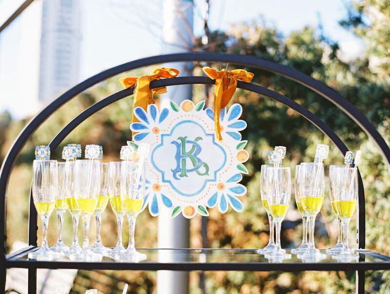 Champagne glasses sitting on a display with a blue and orange monogram decoration